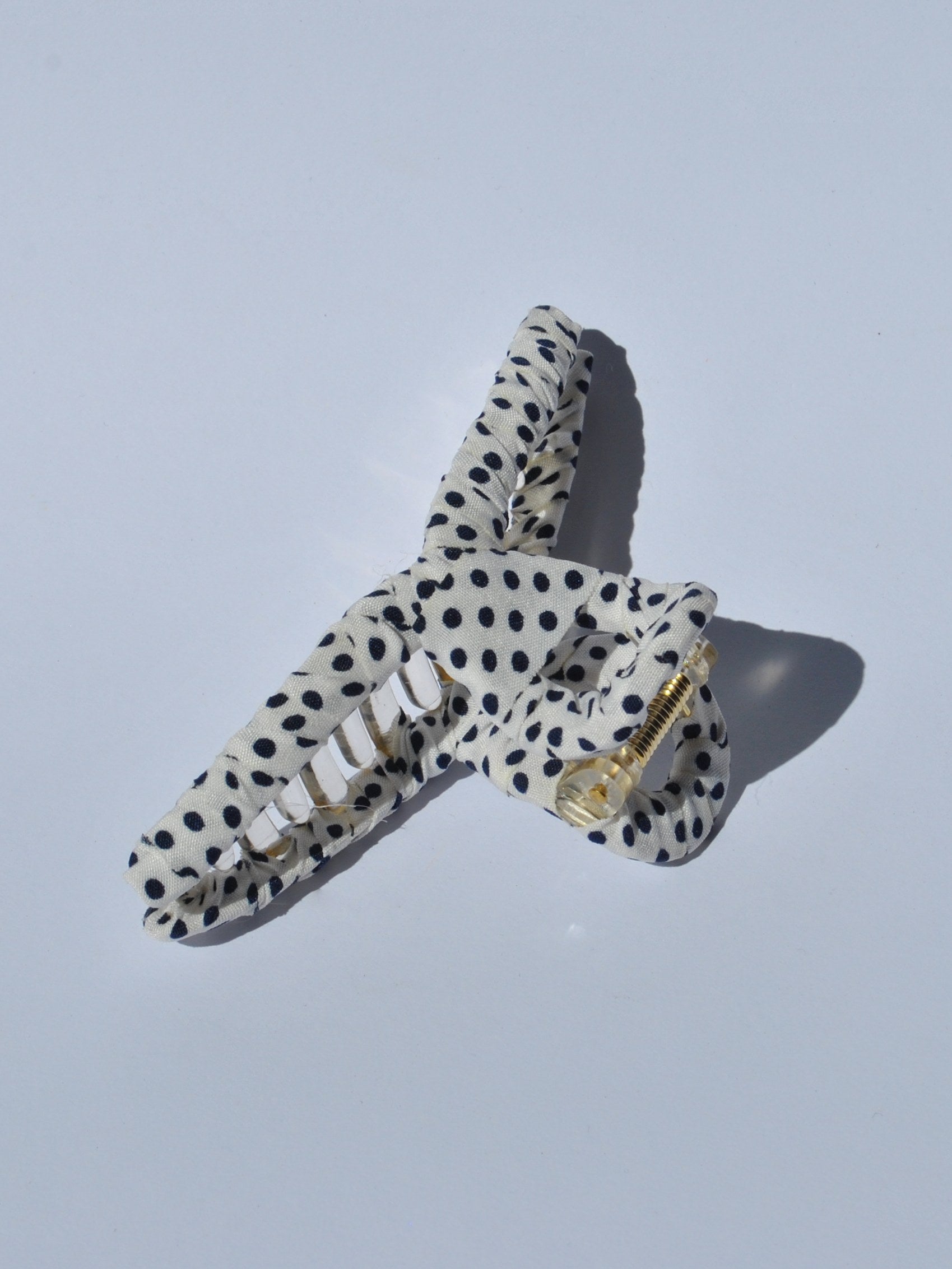 Stylish white with black polka dot claw clip designed for secure all-day hold and comfortable updo hairstyles for women.