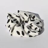 Modern black and white hair tie accessory ideal for casual, work, and weekend looks.