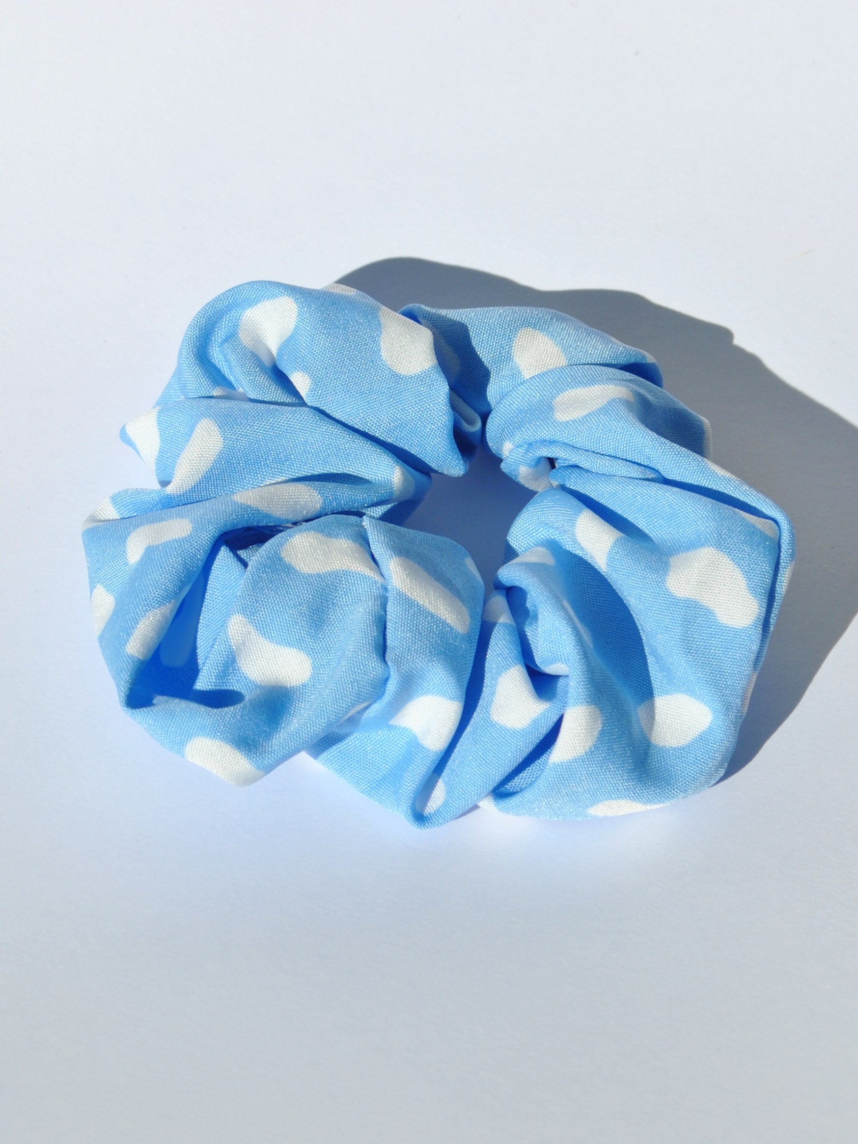 Stylish blue polkadot printed hair scrunchie perfect for creating chic ponytails, messy buns, and updos.