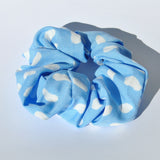 Stylish blue polkadot printed hair scrunchie perfect for creating chic ponytails, messy buns, and updos.