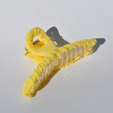 Bright yellow fabric-covered claw clip with translucent details and modern minimalist aesthetic.