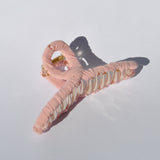 Fashion-forward claw clip in pastel pink for trendy hairstyles and effortless elegance.