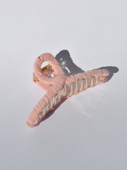 Fashion-forward claw clip in pastel pink for trendy hairstyles and effortless elegance.
