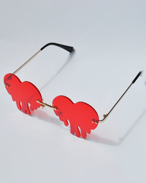 Unique red dripping heart sunglasses with rimless tinted lenses and gold metal frame.