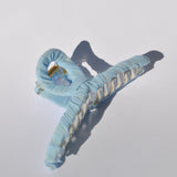 Pastel light blue oversized hair claw clip for women with fabric-wrapped design and secure grip.