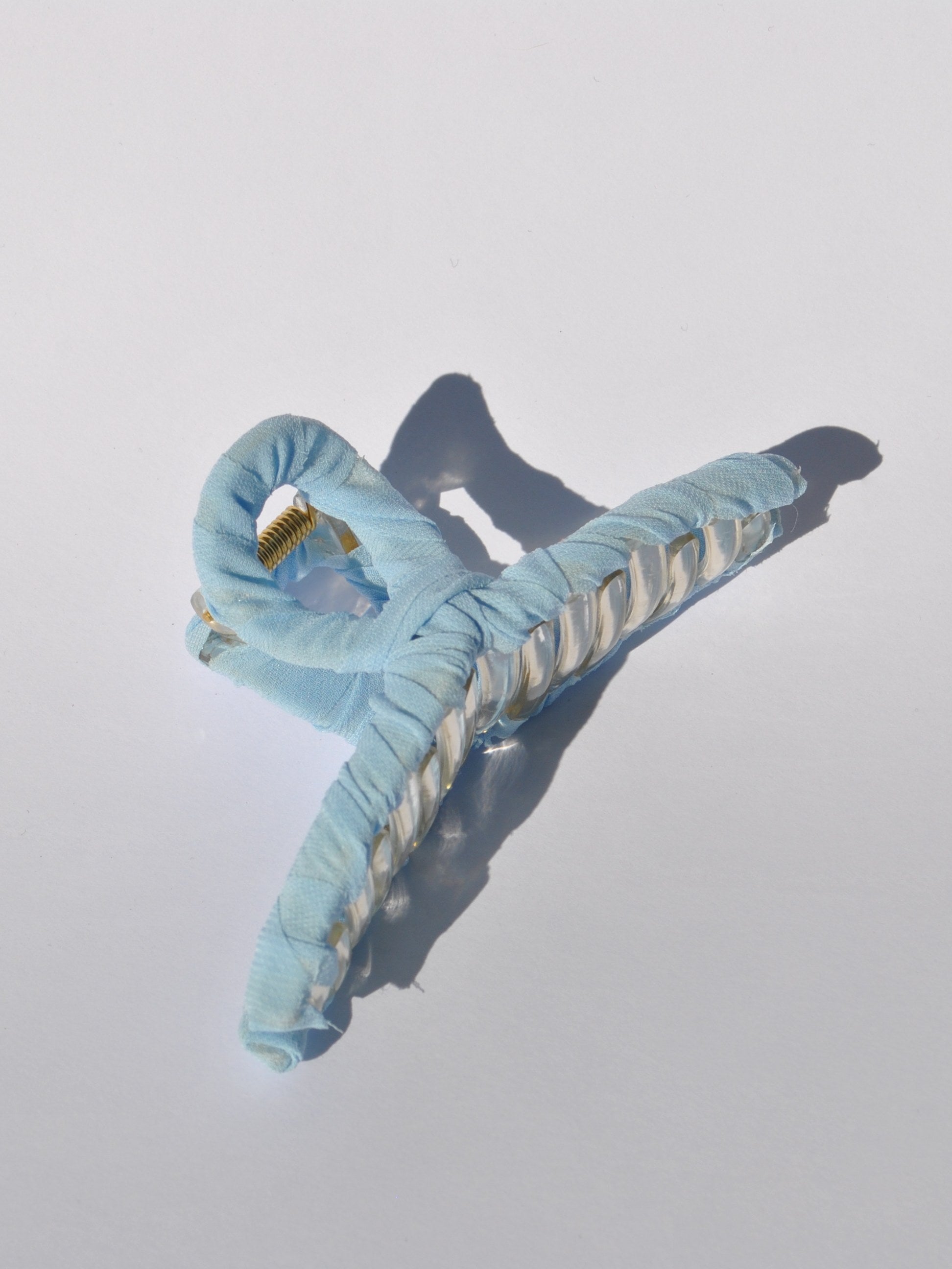Pastel light blue oversized hair claw clip for women with fabric-wrapped design and secure grip.