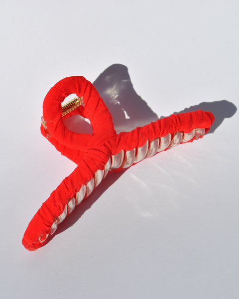Fashion hair accessory featuring bright red fabric and oversized claw construction.