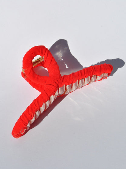 Fashion hair accessory featuring bright red fabric and oversized claw construction.