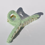 Fashionable mint claw clip with translucent acrylic frame and soft fabric covering.