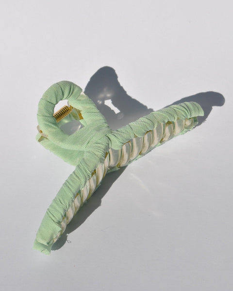 Fashionable mint claw clip with translucent acrylic frame and soft fabric covering.