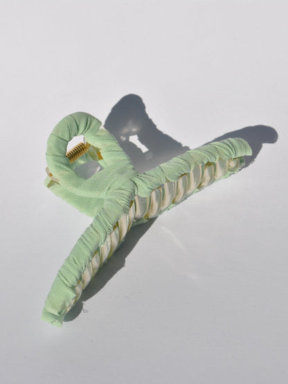 Fashionable mint claw clip with translucent acrylic frame and soft fabric covering.