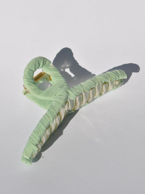 Fashionable mint claw clip with translucent acrylic frame and soft fabric covering.