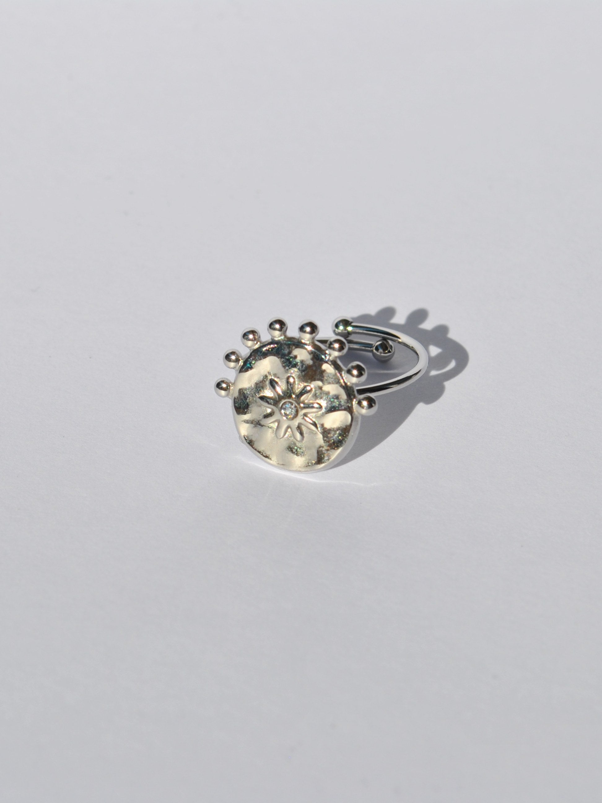 Contemporary silver statement ring with celestial sun engraving and modern adjustable fit for everyday fashion looks.