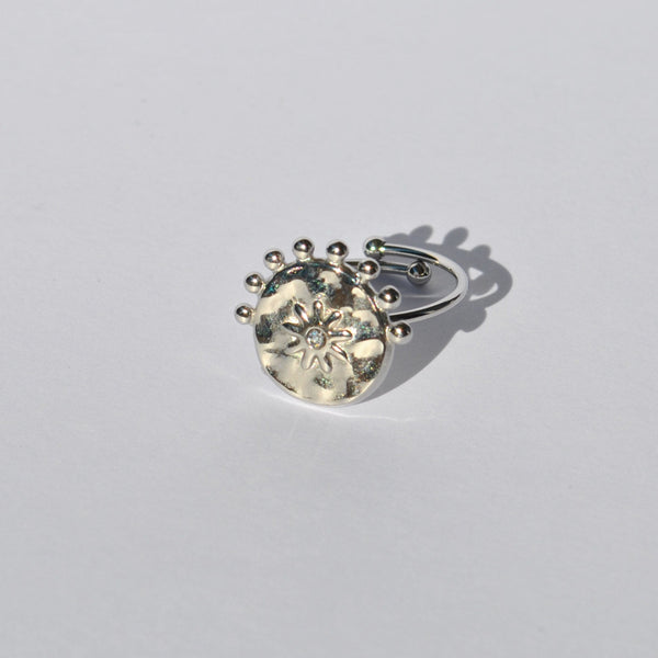 Contemporary silver statement ring with celestial sun engraving and modern adjustable fit for everyday fashion looks.