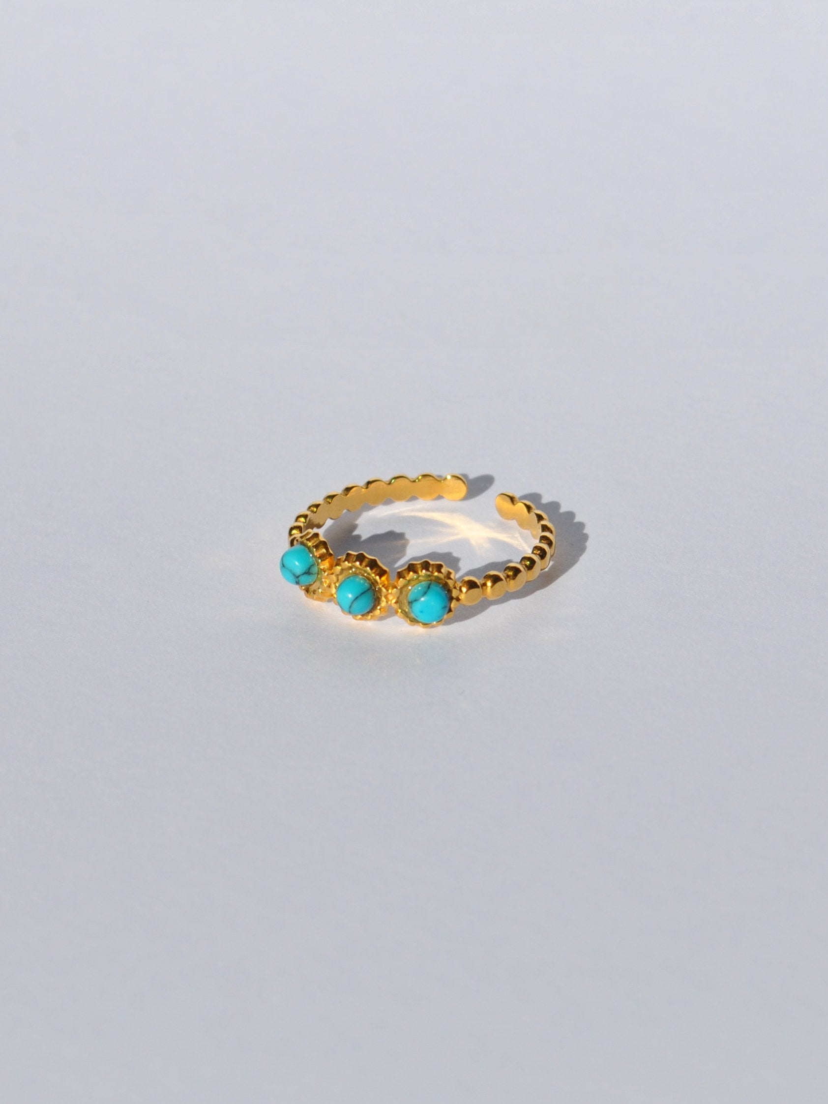 Women’s adjustable gold beaded ring featuring turquoise gemstone accents and minimalist stackable fashion jewelry design.