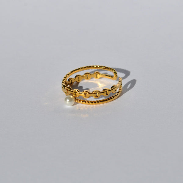 Women’s gold wraparound ring with textured detailing and elegant pearl centerpiece for stylish day-to-night outfits.