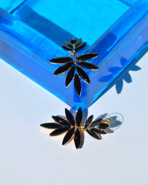 Luxury-inspired black petal earrings with sparkling faceted stones and elegant gold hardware for evening wear fashion.