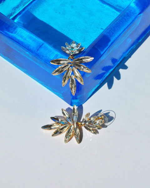 Glamorous crystal dangle earrings featuring modern botanical design and lightweight statement silhouette.
