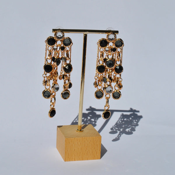 Trendy statement dangle earrings with black jewel detailing and glamorous gold finish for upscale party wear.