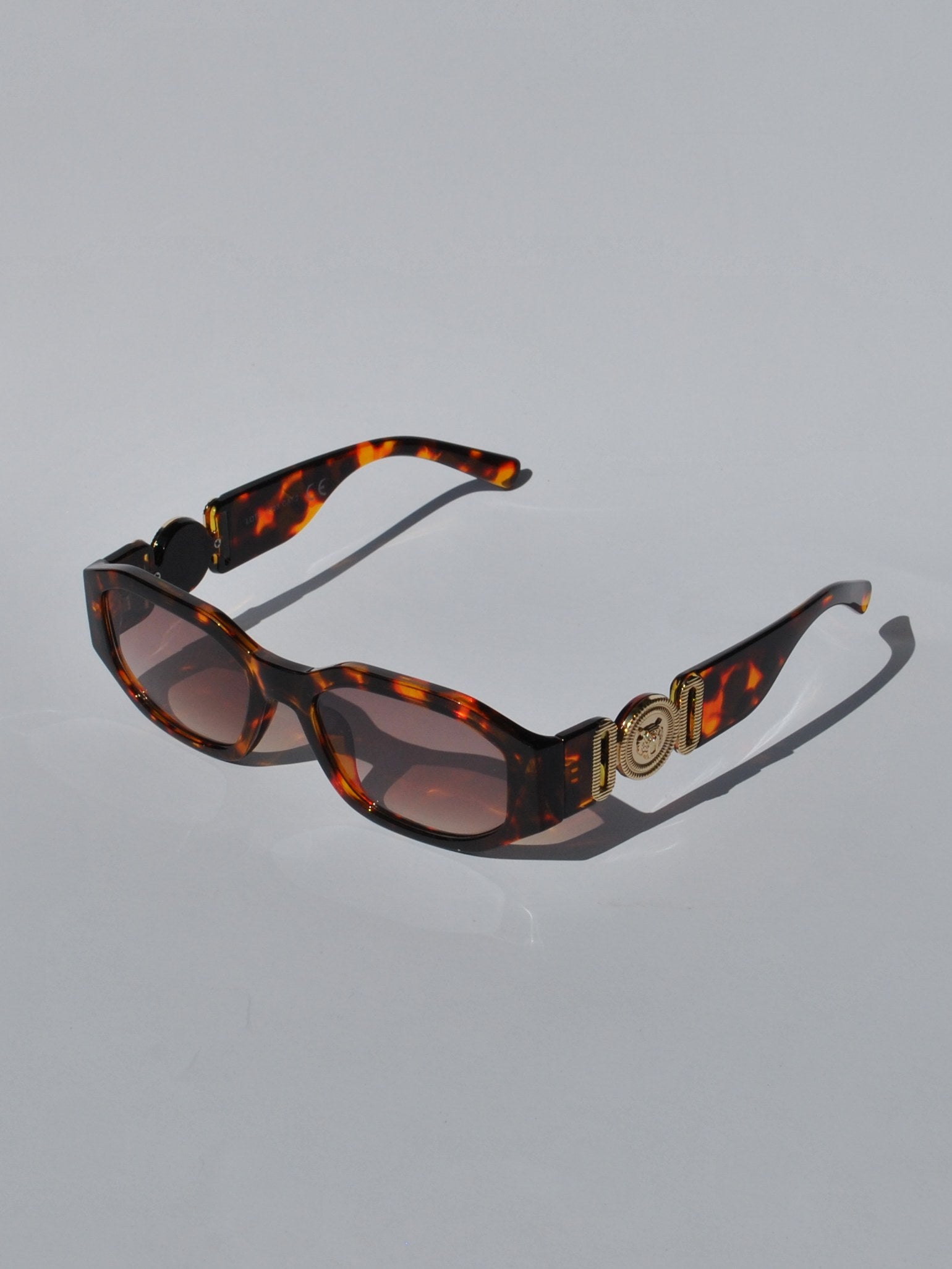 Trendy tortoiseshell sunglasses featuring chunky square frames and designer-inspired gold temple accents for statement styling.