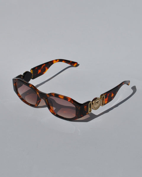 Trendy tortoiseshell sunglasses featuring chunky square frames and designer-inspired gold temple accents for statement styling.