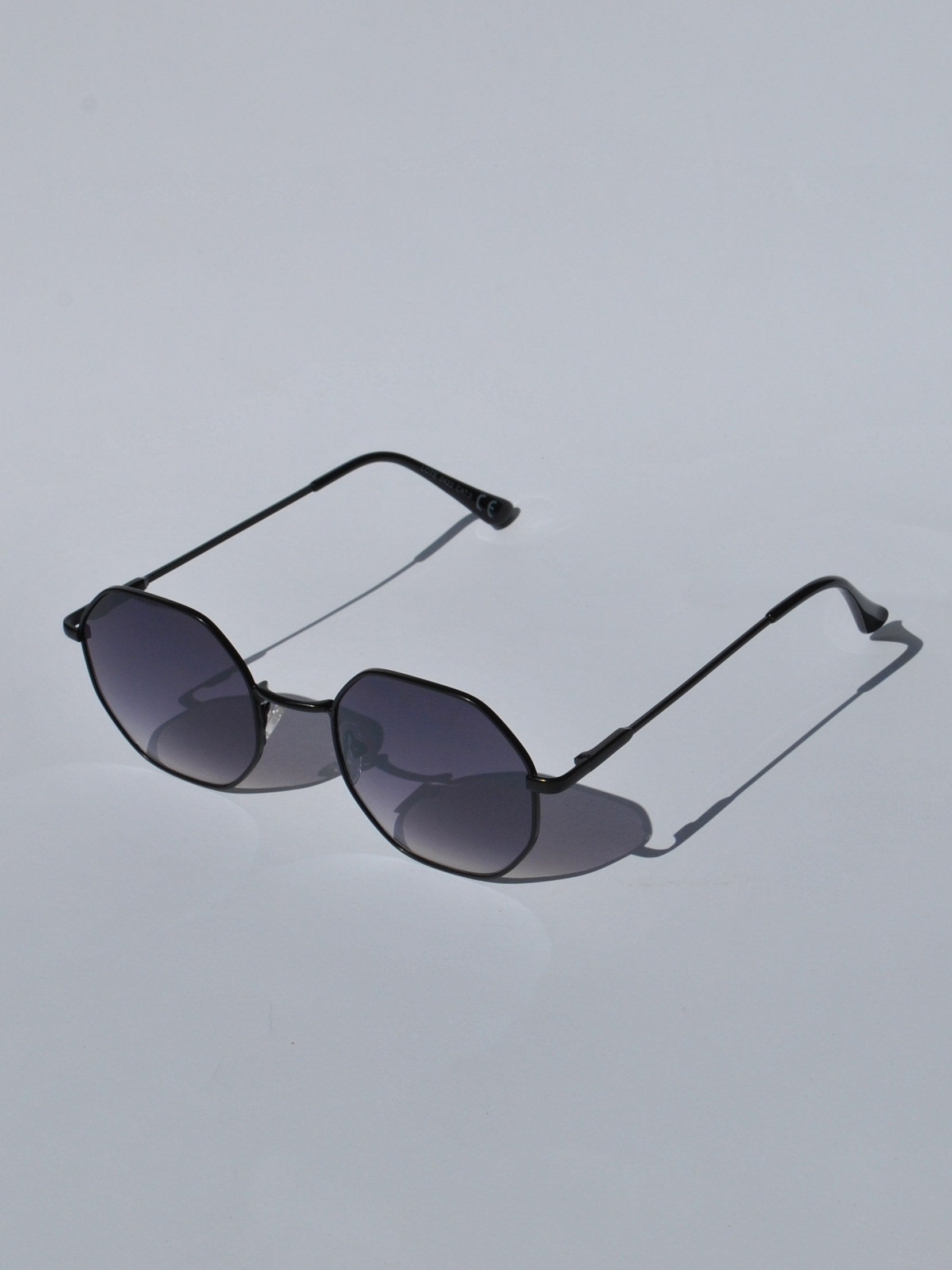 Modern geometric sunglasses for women with slim black metal frames and trendy oversized hexagon lens shape.
