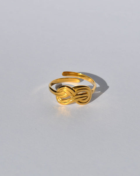 Chic gold open ring featuring a modern knot motif and polished metallic finish for trendy everyday jewelry looks.