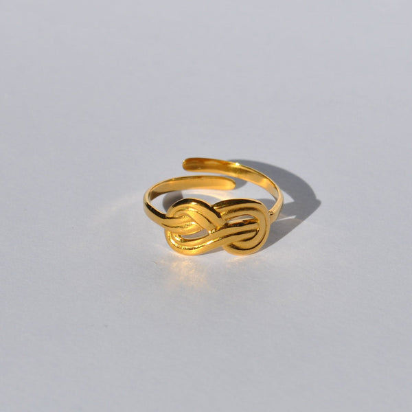Chic gold open ring featuring a modern knot motif and polished metallic finish for trendy everyday jewelry looks.