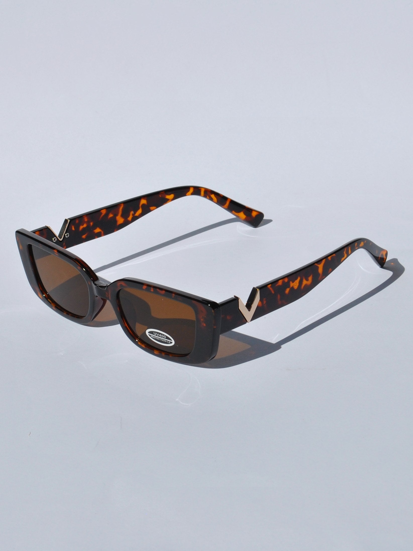 Stylish rectangular tortoise sunglasses with dark tinted lenses and retro 90s aesthetic for casual and vacation wear.