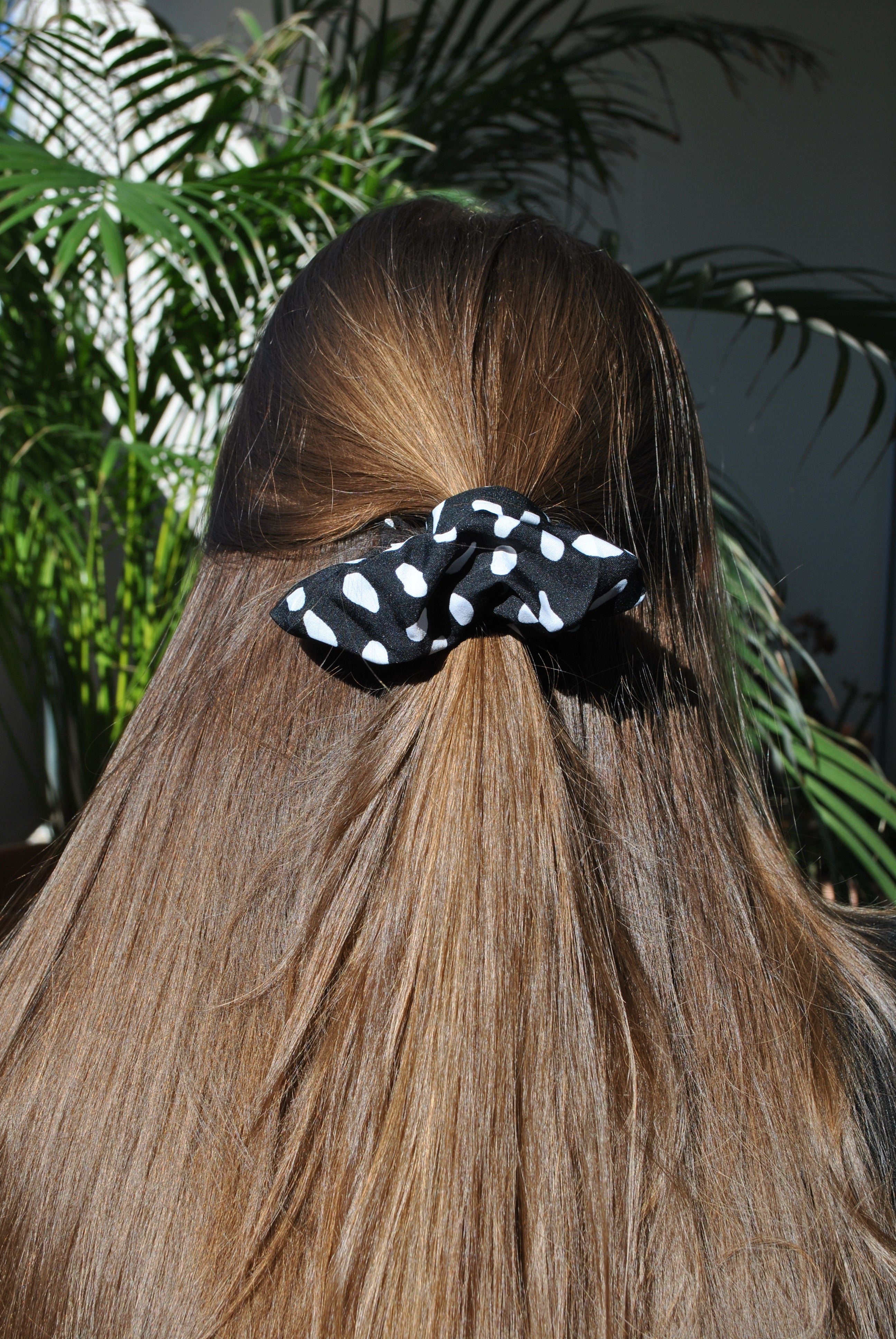 Trendy black polkadot fabric scrunchie with white polka dot print for effortless everyday styling.