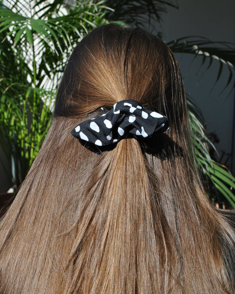 Trendy black polkadot fabric scrunchie with white polka dot print for effortless everyday styling.