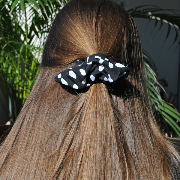 Trendy black polkadot fabric scrunchie with white polka dot print for effortless everyday styling.