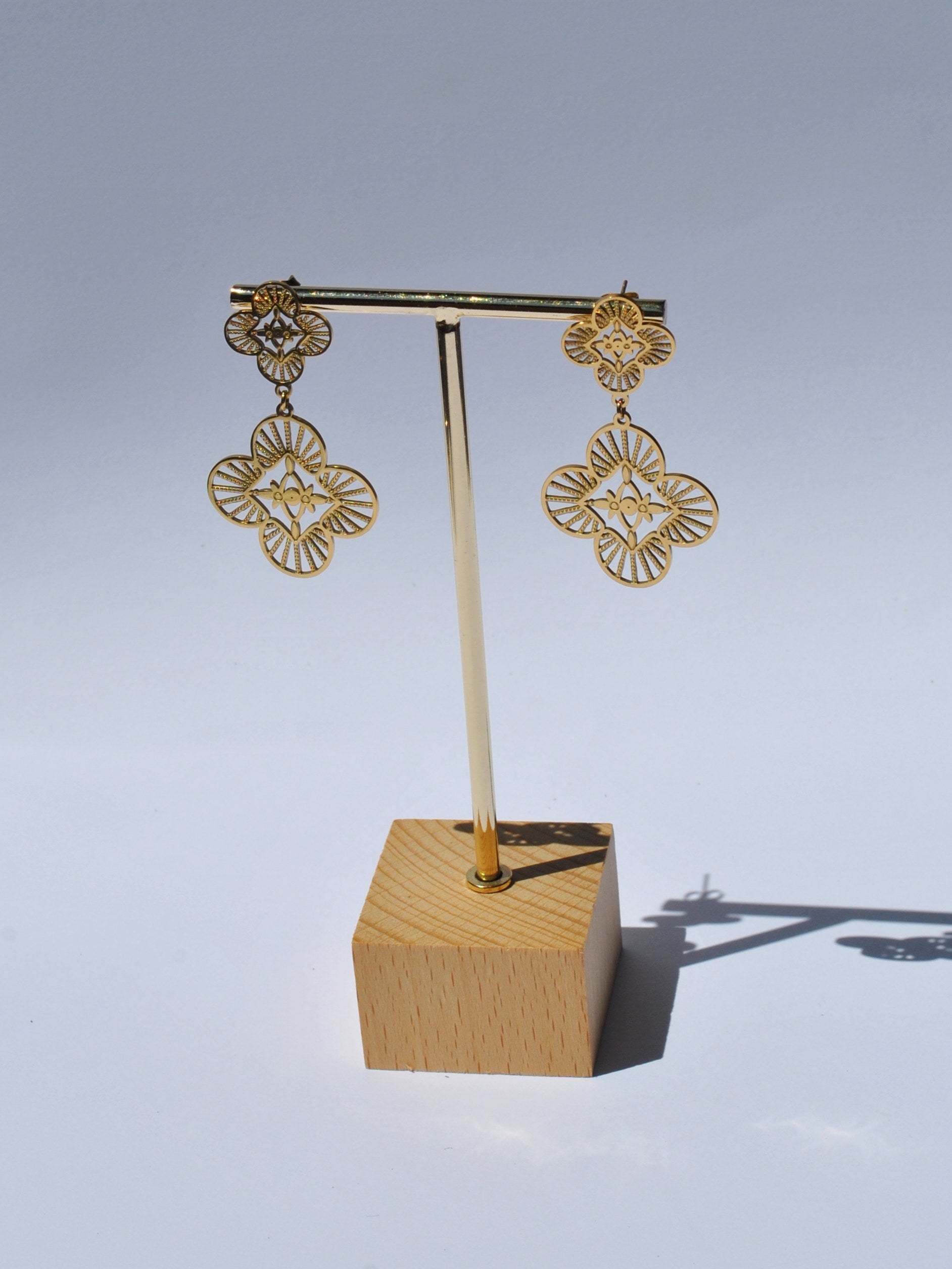 Luxury gold filigree drop earrings with floral clover design and elegant statement jewelry styling for women.