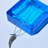 Gold wing statement necklace with feather-textured pendant and slim chain for trendy women’s fashion accessories.