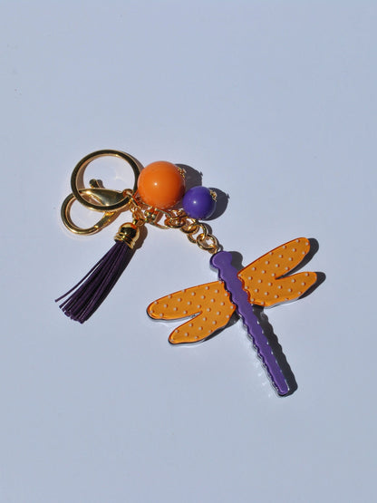 Fun fashion keychain with vibrant dragonfly pendant and decorative tassel for stylish backpack, tote, or handbag accessorizing.