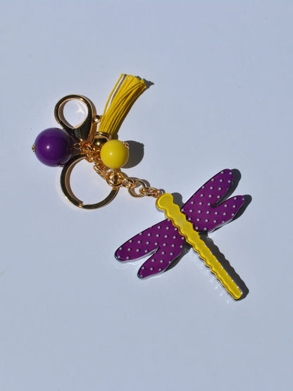 Cute women’s handbag charm with whimsical dragonfly design, colorful beads, and luxe gold-tone clasp for trendy accessories.