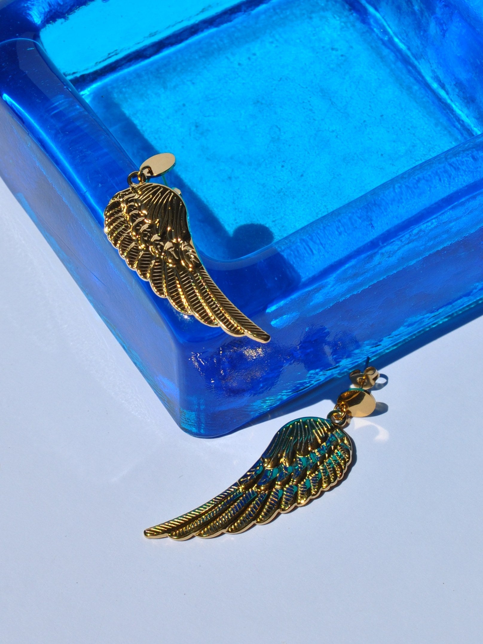 Fashion gold wing earrings with intricate feather detailing for edgy bohemian and contemporary jewelry styling.