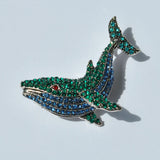 Elegant crystal whale brooch with green and blue rhinestones for nautical fashion.