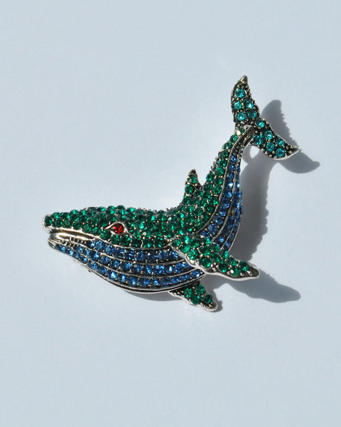 Elegant crystal whale brooch with green and blue rhinestones for nautical fashion.