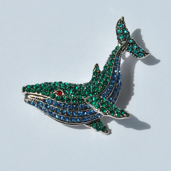 Elegant crystal whale brooch with green and blue rhinestones for nautical fashion.