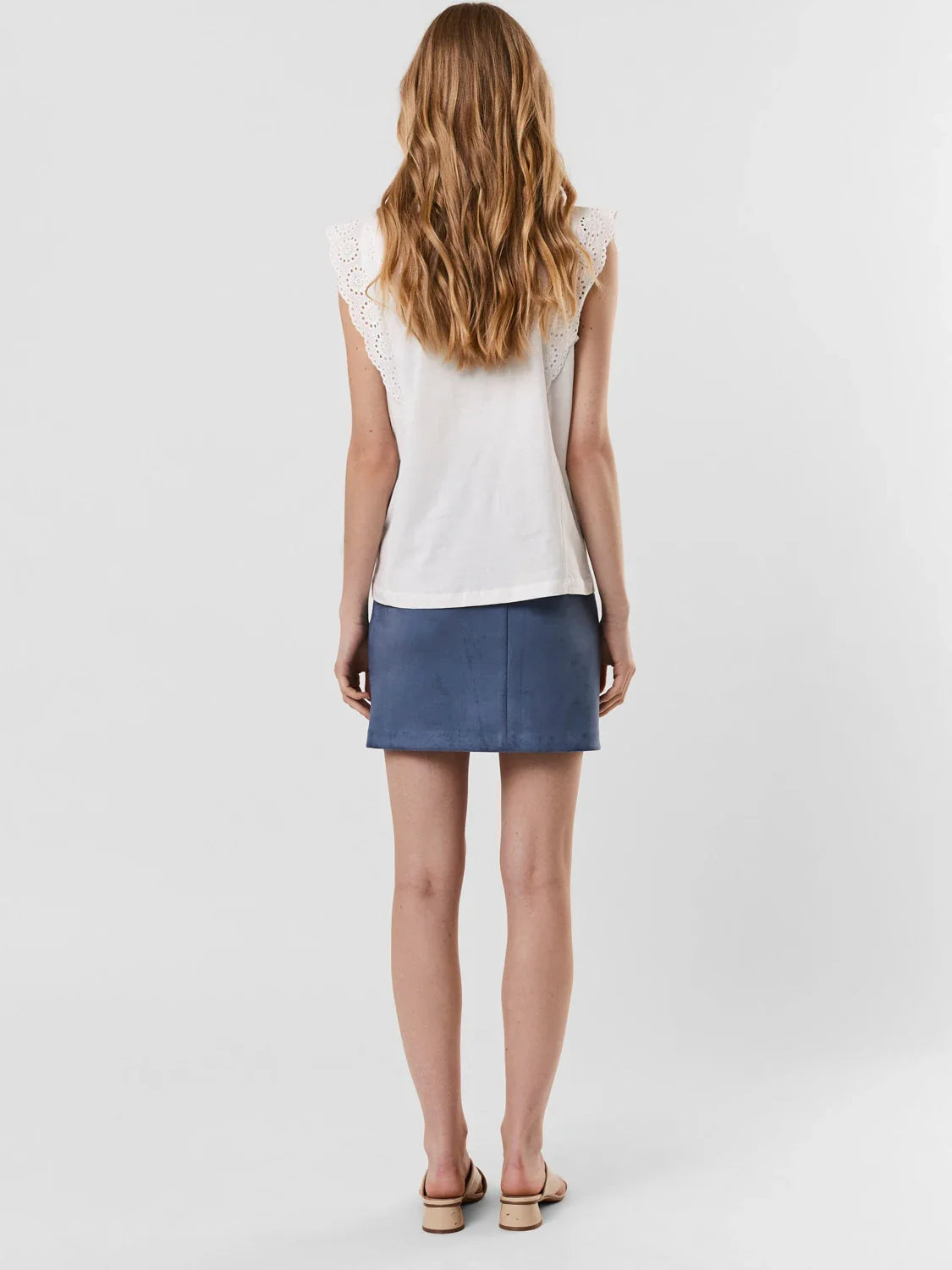 Women's embroidered sleeveless blouse with delicate eyelet flutter sleeve detail.