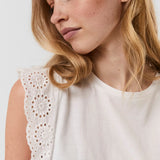 Women's white eyelet lace top featuring delicate embroidery and sleeveless silhouette.