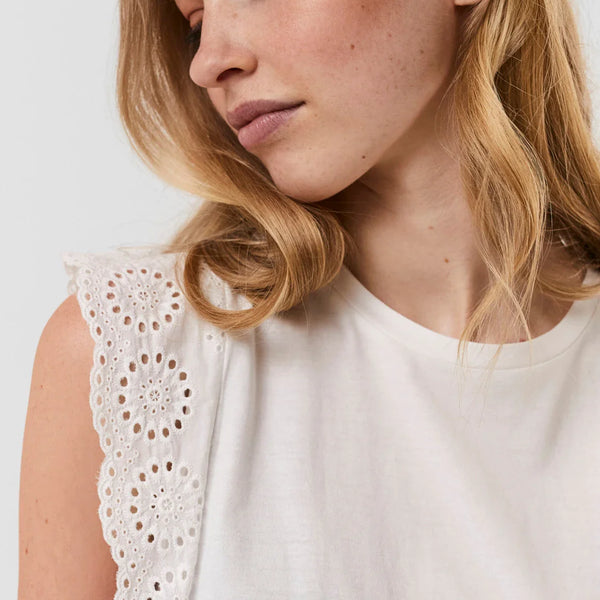 Women's white eyelet lace top featuring delicate embroidery and sleeveless silhouette.