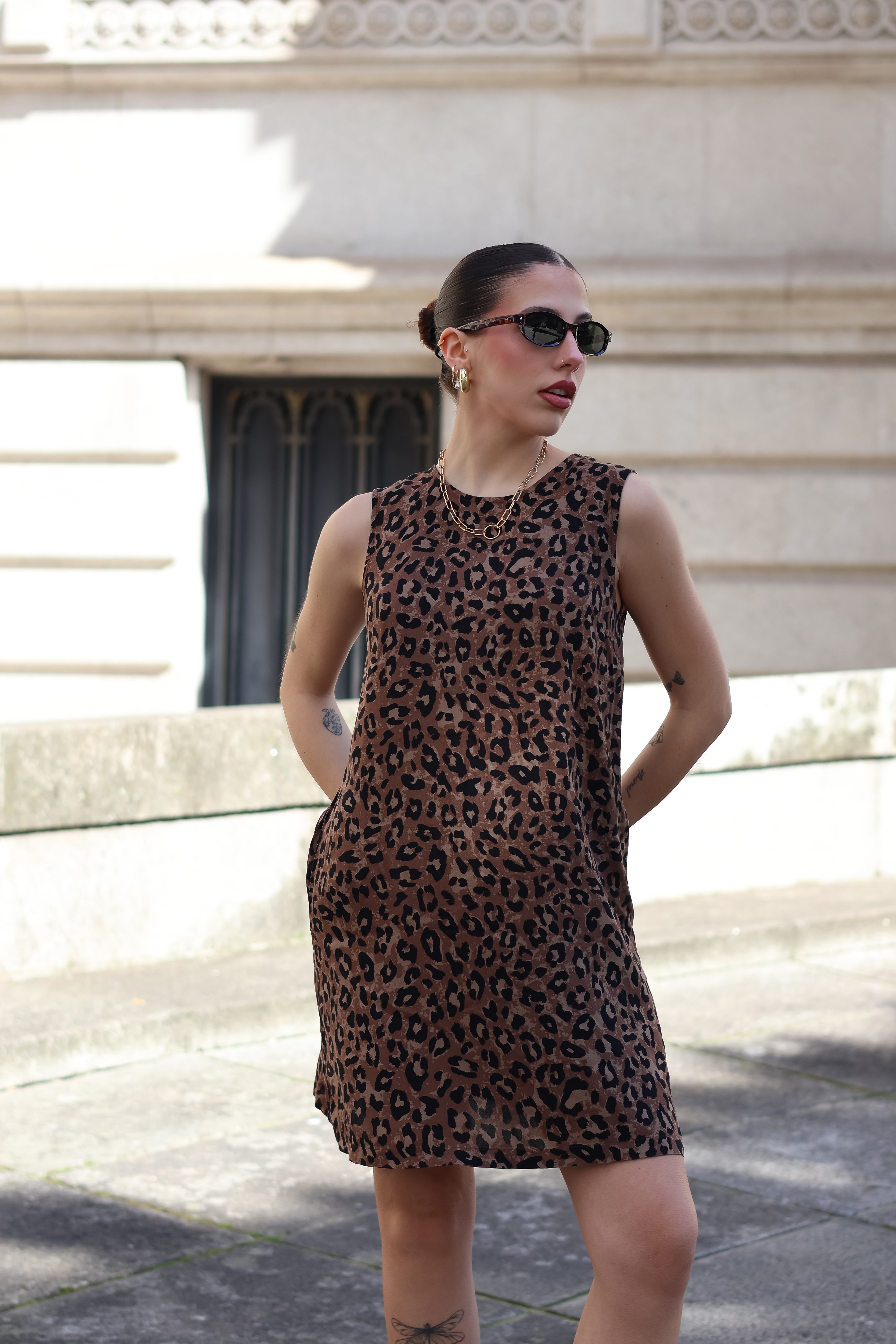 Contemporary leopard print shift dress paired with sunglasses for chic European summer fashion aesthetic.