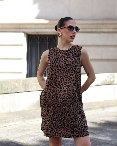 Contemporary leopard print shift dress paired with sunglasses for chic European summer fashion aesthetic.