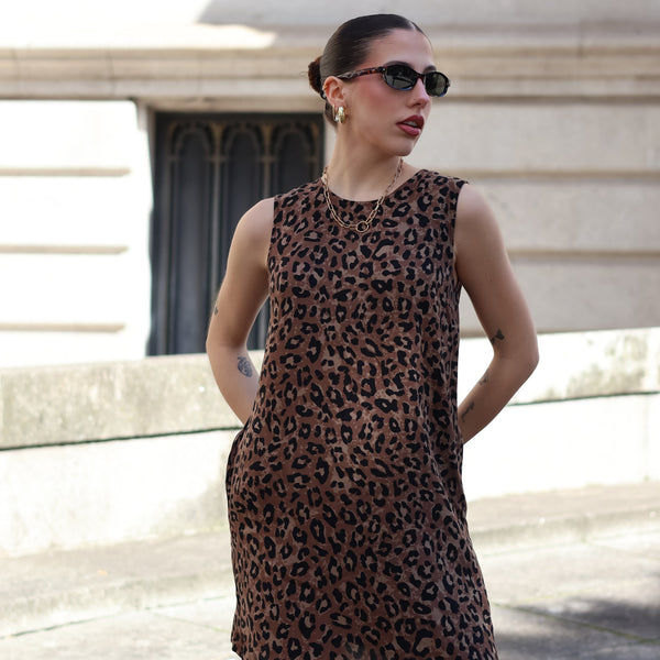 Contemporary leopard print shift dress paired with sunglasses for chic European summer fashion aesthetic.