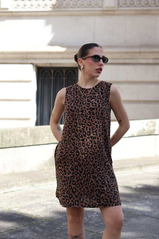 Contemporary leopard print shift dress paired with sunglasses for chic European summer fashion aesthetic.