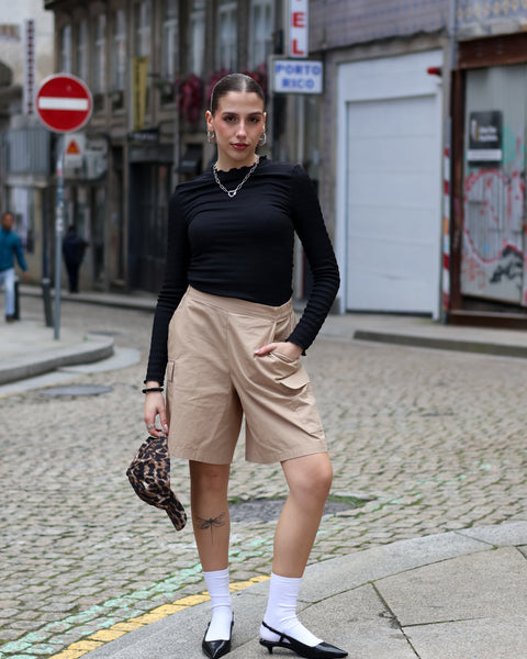 Women’s modern cargo Bermuda shorts paired with chunky loafers for edgy contemporary streetwear style.