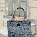 Elevated resort handbag with artisanal blue woven fabric and minimalist luxe aesthetic for vacation outfits.