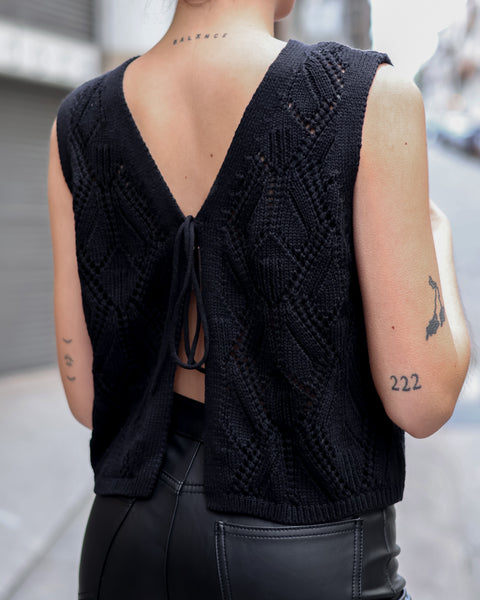 Back and tie detail of fashion-forward black crochet vest with breathable knit texture and elevated casual-chic silhouette.
